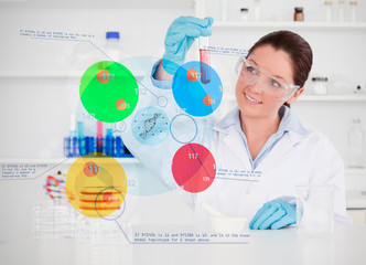 Smiling chemist looking at test tube