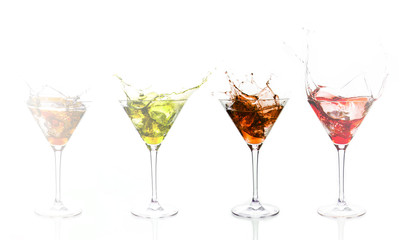 Serial arrangement of coloured alcohol splashing in cocktail gla