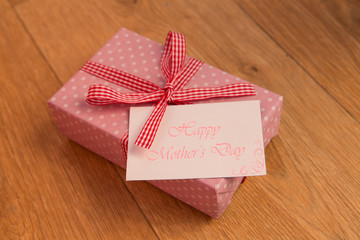 Pink wrapped present with mothers day card