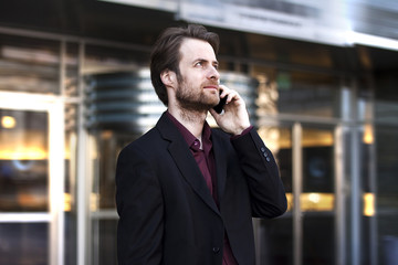 Businessman outside office building talking on a mobile phone