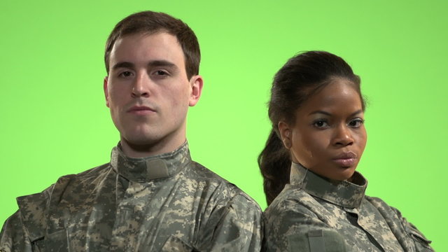 Soldiers in front of green screen standing back to back.