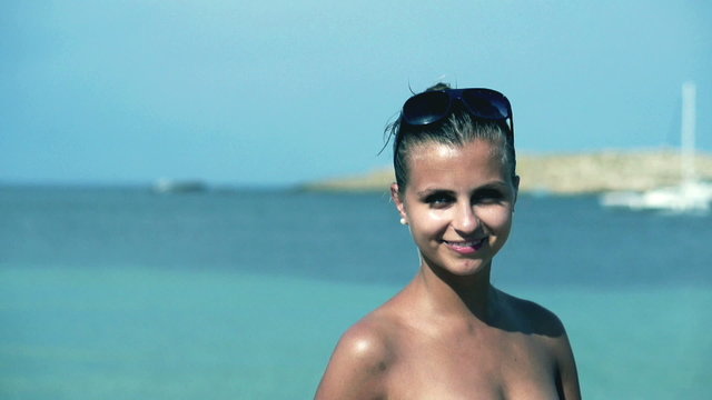 Beautiful girl standing on the beach and smiling, slow motion sh