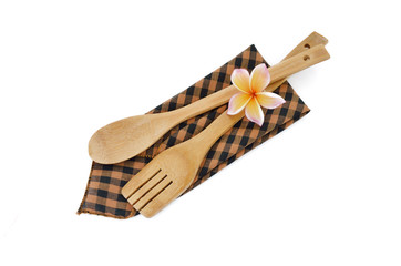 Wooden cooking utensils with checkered cloth isolated on white