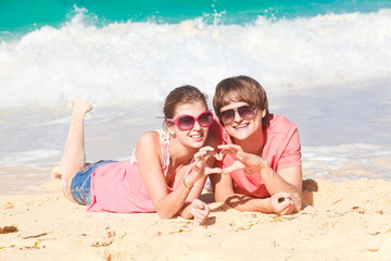 beautiful young couple sitting and having fun on beach