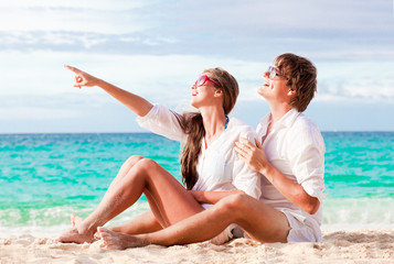 young happy couple having fun on tropical beach. honeymoon