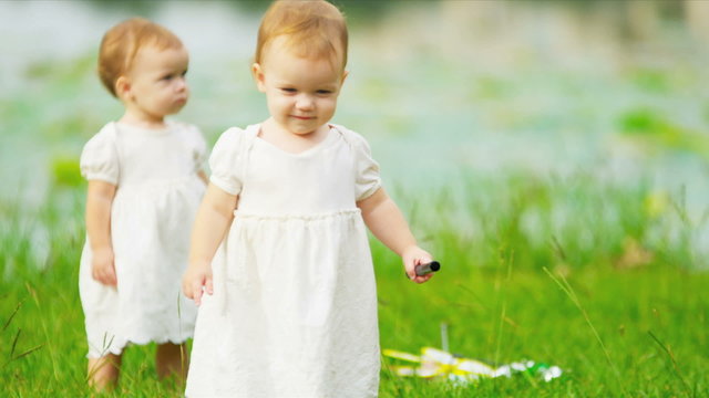 Happy Caucasian children toddling together in park