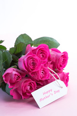 Bouquet of pink roses with happy mothers day card on a table