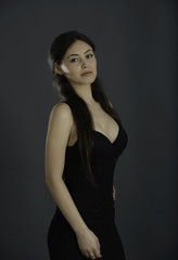 Naklejka premium Portrait of beautiful brunette woman in black dress
