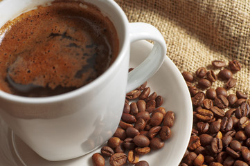 Closeup cup of coffee and coffee beans