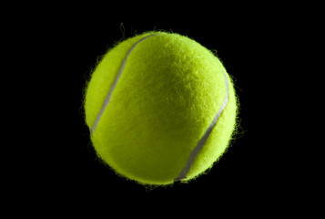 Gr&uuml;ner Tennisball vor schwarzem Hintergrund