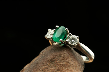 White gold ring with diamonds and emerald stone