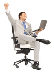 young businessman sitting in chair with laptop