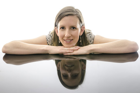 Smiling Young Woman Leaning On A Table