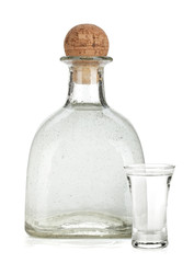 Bottle of silver tequila and shot with lime slice