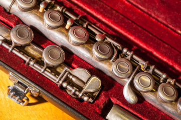 Close-up of vintage brass flute in red velvet case
