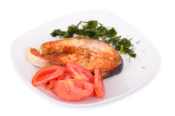 Salmon steak with vegetables on plate. Isolated on white
