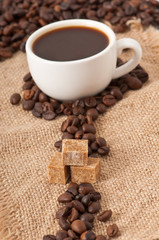 Cubes brown sugar and cup of coffee