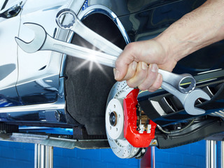 Close up of a hand with tools in front of a brake