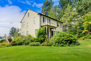 Obraz premium Large brown house exterior with summer garden.