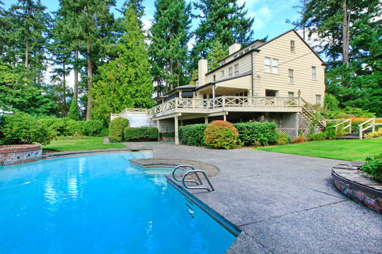 Large Brown House Exterior With Summer Garden And Swimming Pool