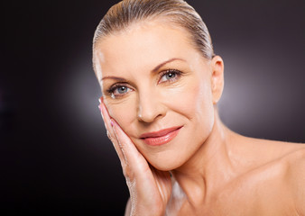 elegant mature woman over black background