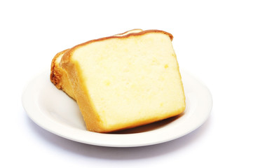 Sliced butter cake on plate with white background