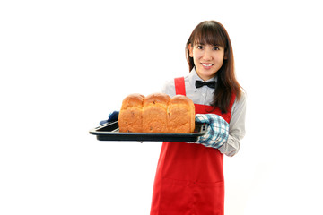 パンを運ぶ笑顔の女性