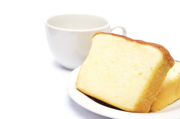 Fototapeta na wymiar Sliced butter cake and cup of coffee on white background