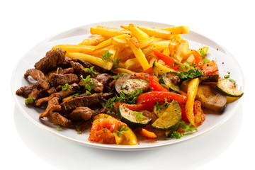 Grilled meat with French fries and vegetables