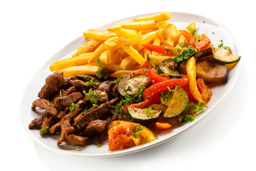 Grilled meat with French fries and vegetables