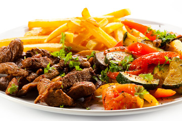 Grilled meat with French fries and vegetables