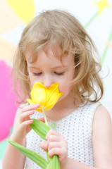 Cute little girl with yellow tulip