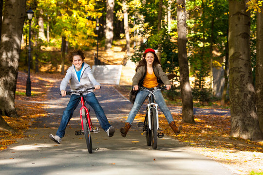 Urban Biking - Teens Riding Bikes In City Park