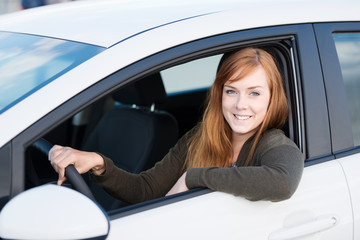 lächelnde junge frau in ihrem auto