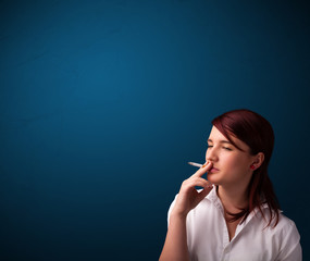 Beautiful woman smoking cigarette vith copy space