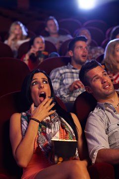 Young woman shocked at cinema