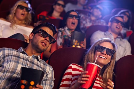 Audience watching 3D film at cinema