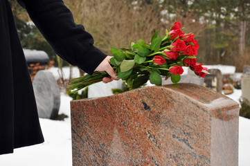 Junge Frau legt Blumen nieder