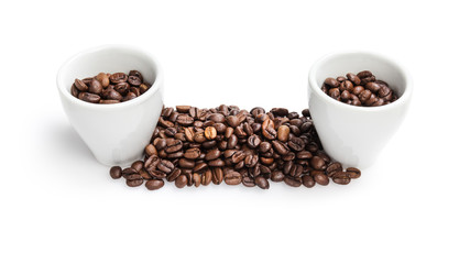 heap of coffee beans with two cups