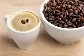 espresso in a cup and cup full of beans