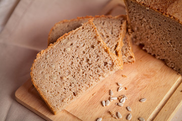 Sliced dark bread with crumbs on sacking background