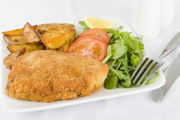 Wiener Schnitzel - Breaded fried veal, potato wedges and salad.