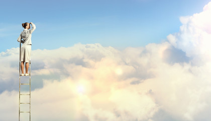 Businesswoman standing on ladder © Sergey Nivens