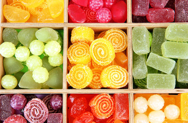 Multicolor candies in wooden box, close up