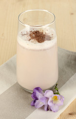Glass of chocolate-cream cocktail on wooden table close-up