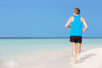 Fototapeta na wymiar Senior Man Running On Beautiful Beach