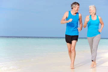 Senior Couple Running On Beautiful Beach