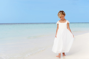 Fototapeta na wymiar Young Girl In Bridesmaid Dress Walking On Beautiful Beach