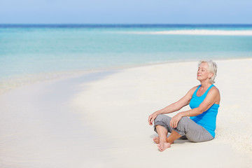 Fototapeta na wymiar Senior Kobieta Medytacji na pięknej plaży