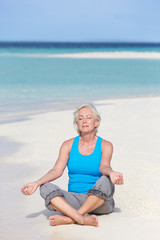 Fototapeta na wymiar Starszy kobieta medytacji na pięknej plaży